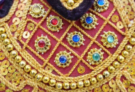 Gastronomic Gems - A close up of a gold and red dress with gold and red beads
