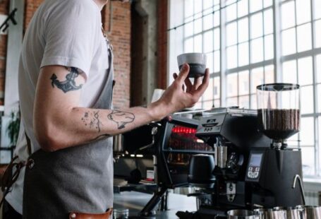 Coffee Tasting - Man in White T-shirt Pouring Coffee on Black Coffee Maker