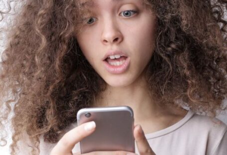 Coffee-Making Secrets - Surprised young woman browsing mobile phone