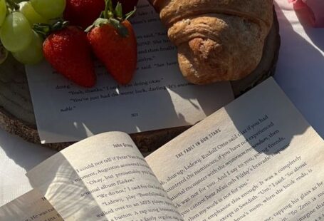 Picnic Spots - A book, bread, grapes and strawberries on a beach